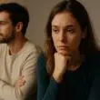 Jeune couple silencieux, assis l’un à côté de l’autre, illustrant le doute émotionnel entre amour véritable et simple attachement — une scène intime et introspective qui reflète les questionnements sur les sentiments profonds.